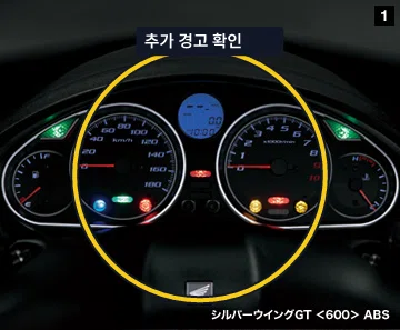 정차된 오토바이 계기판 전체에서 추가 브레이크 관련 경고 여부를 확인하는 이미지